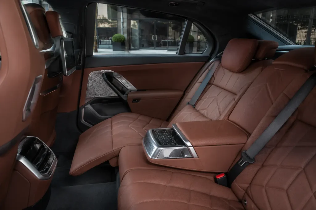 BMW i7 Executive Lounge rear seat with reclining passenger and extended leg rest.